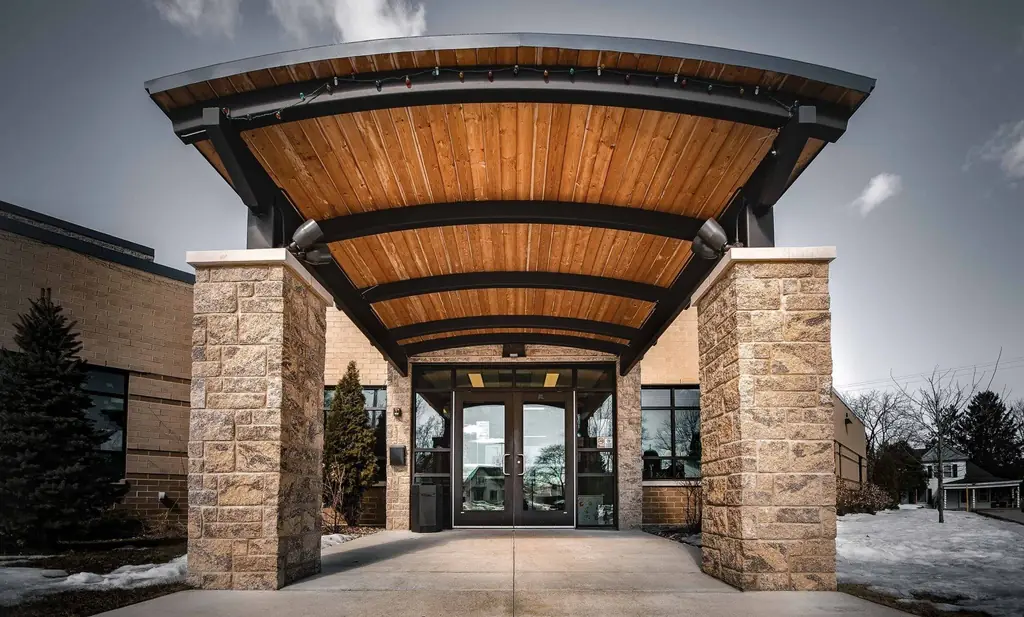 The curved timber and steel entrance canopy at The Club Teen Center, built by Cardinal Construction